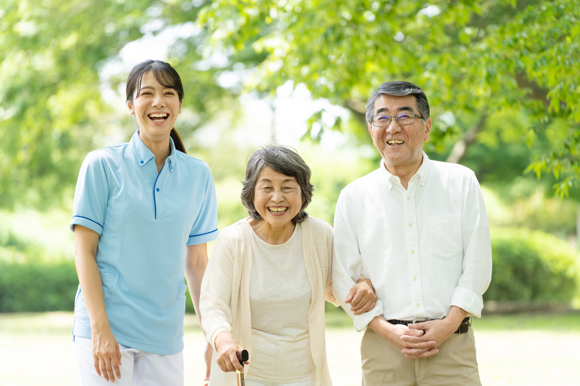 ご夫婦に付き添って笑顔で歩く訪問看護師