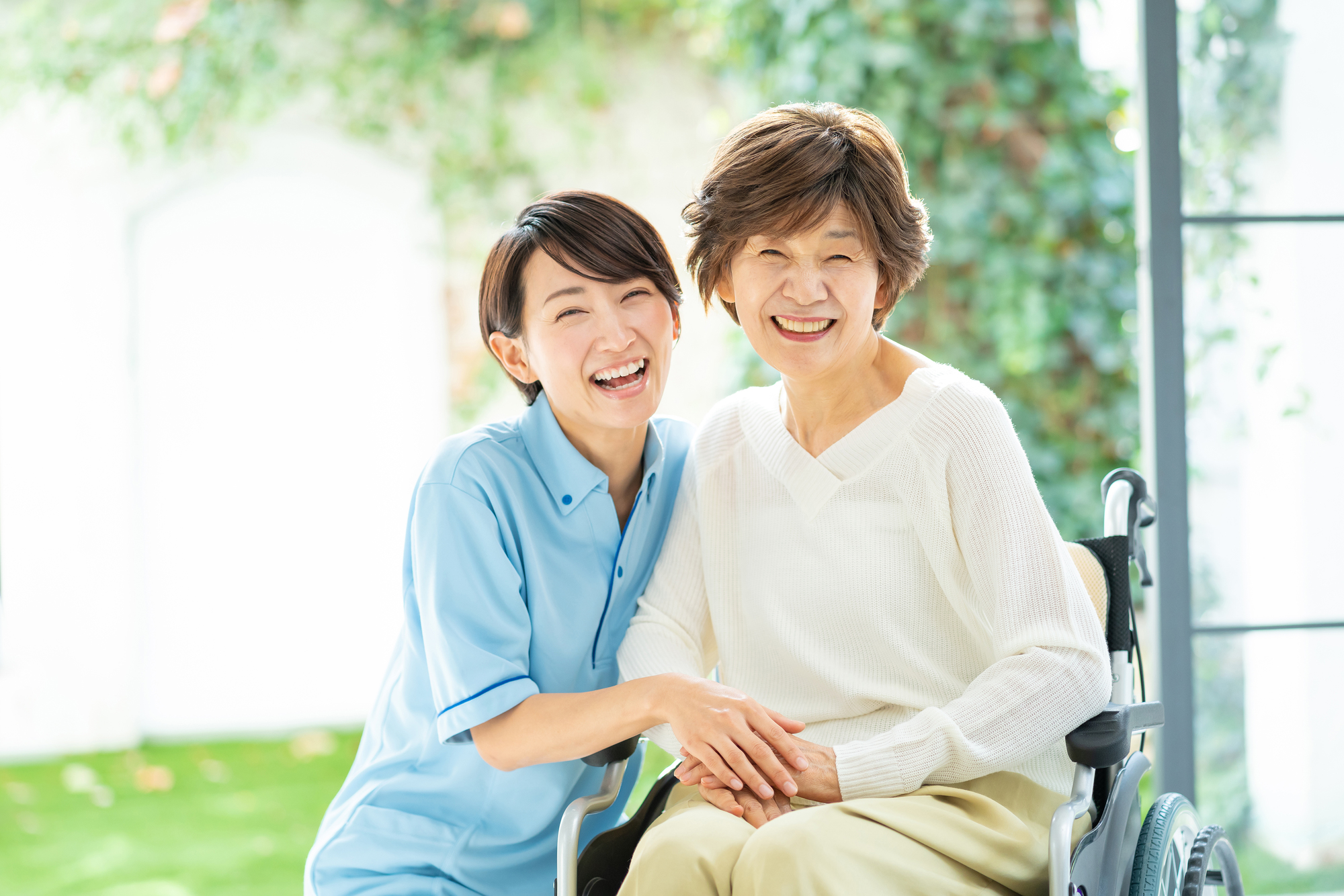 笑顔で寄り添う看護師と車いすの利用者様